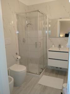 uma casa de banho com um chuveiro, um WC e um lavatório. em Villa Beatrice em Brescia