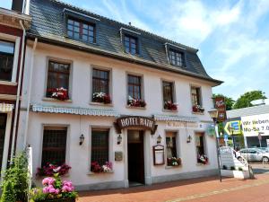 ein weißes Gebäude mit Blumen in den Fenstern in der Unterkunft Hotel Rath in Schwalmtal