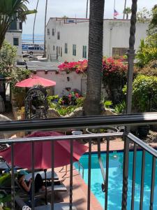 a person sitting in a pool with an umbrella at Villa Rosa Inn in Santa Barbara