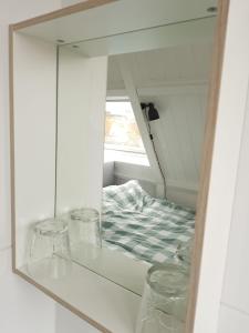 a mirror reflection of a bed in a bedroom at B&B Alkmaars Toppunt in Alkmaar
