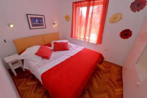 um quarto com uma cama vermelha e branca e uma janela em Villa MT em Posedarje