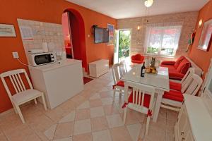 a kitchen and living room with orange walls and a table at Villa MT in Posedarje