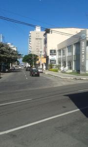 an empty street with a car driving down the street at Hospedagem Praia de Itaparica in Vila Velha