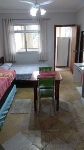 a bedroom with a table and a bed and a table and chair at Hospedagem Praia de Itaparica in Vila Velha