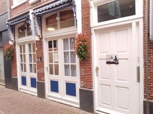 ein Paar weiße Türen auf einem Backsteingebäude in der Unterkunft B&B Alkmaars Toppunt in Alkmaar