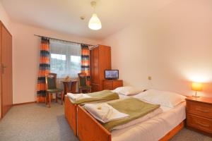 a bedroom with a bed and a table and chairs at Ośrodek U Fojta in Wisła