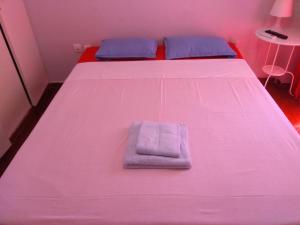 a pink bed with a towel on top of it at Wonderful Apartment in central Athens in Athens