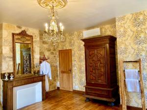 La salle de bains est pourvue d'un lustre et d'un miroir. dans l'établissement Les Petits Cousins Du Québec - Chambres D’hôtes à Domme, à Domme