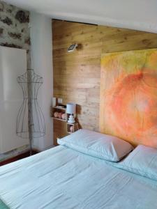 1 dormitorio con 1 cama con una pintura en la pared en Abbracci Home Barbarano, en Barbarano Romano