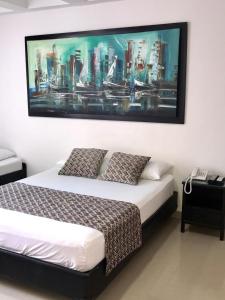 a bedroom with a bed with a large painting on the wall at Apartamentos Cartagena Caribe Suite in Cartagena de Indias
