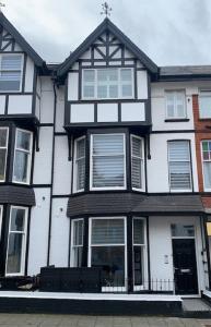 a white and black house with a cross on top at Sandleigh Apartment in Scarborough
