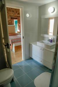 a bathroom with a sink and a toilet and a bedroom at Farmakas Living in Farmakas