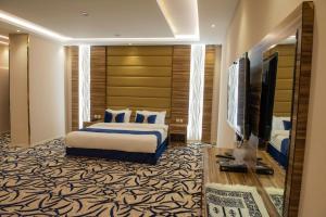 a hotel room with a bed and a flat screen tv at وابل للوحدات السكنية in Abha