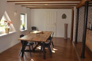 een eetkamer met een houten tafel en stoelen bij Ferienwohnung Grafenland in Dersum