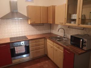 a small kitchen with wooden cabinets and a sink at SleepCheaper in Bergen