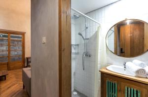 a bathroom with a shower and a sink with a mirror at Ruang Tekuni in Legian