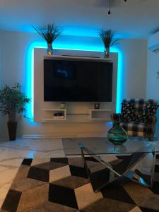 C'DaView Apartment Suite في خليج مونتيغو: غرفة معيشة مع تلفزيون بشاشة مسطحة مع أضواء زرقاء
