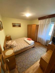 a small bedroom with a bed and a window at Apartament Slanic Moldova in Slănic-Moldova