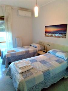 CasaSylvia في كاسانو ديلي مورجي: غرفة نوم بسريرين ولوحة على الحائط