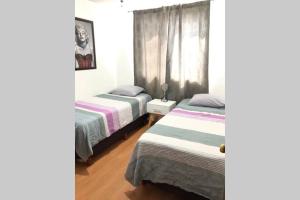 um quarto com 2 camas e uma janela em La casa de Glo em Guadalajara