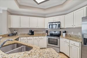 a kitchen with white cabinets and stainless steel appliances at The Oasis at Orange Beach (formerly Phoenix West II) in Orange Beach