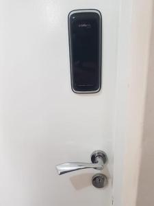 un teléfono celular sentado en la parte superior de una puerta con un mango en Jardim Europa, en Balneário Camboriú