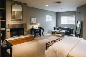 a bedroom with a bed and a living room with a fireplace at Seven Branches Venue and Inn in Sonoma