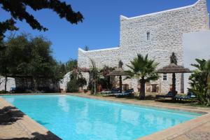 a swimming pool in front of a building at Riad Sanam - Adults only in Essaouira