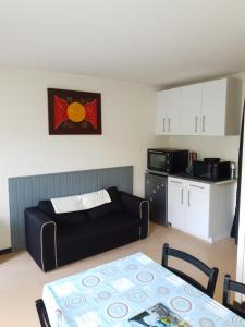 a living room with a couch and a table and a kitchen at imperatrice eugenie in Luz-Saint-Sauveur