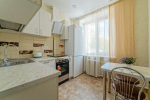 a kitchen with a sink and a stove top oven at Apartments on Ploscha Yakuba Kolasa in Minsk