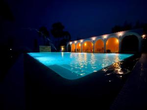 ein großer Swimmingpool in der Nacht mit Lichtern in der Unterkunft Riviera Beach Resort in Chīrāla