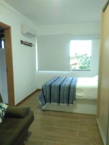 1 dormitorio con cama y ventana en Apartamento no bairro de Mariscal a 300 metros praia do Canto Grande, en Bombinhas