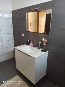 La salle de bains est pourvue d'un lavabo blanc et d'un miroir. dans l'établissement The Goat's Place, à Gaula