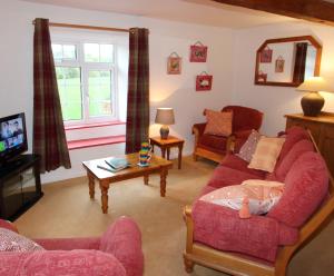 a living room with two couches and a tv at Wonderfully Scenic and Comfortable Dales Mill Property in West Burton