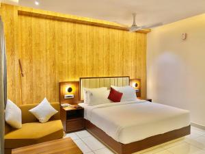 a hotel room with a bed and a chair at Riviera Beach Resort in Chīrāla