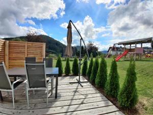 een patio met een tafel, een parasol en een speeltuin bij Lieblingsplatz - Willingen inklusive MeineCardPlus in Willingen