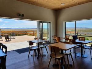 a restaurant with tables and chairs and a large window at Pukaki Air Lodge in Twizel