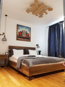 1 dormitorio con 1 cama grande y cortinas azules en Old Bakery House en Sinaia