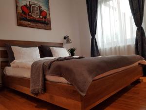 Un dormitorio con una gran cama de madera con almohadas blancas. en Old Bakery House en Sinaia