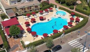 an overhead view of a pool with tables and umbrellas at Hotel Le Tegnue in Sottomarina