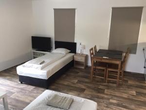 - une chambre avec un lit, une table et un bureau dans l'établissement Akali studio apartments, à Balatonakali