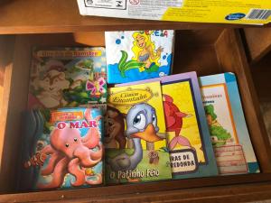 una pila de libros infantiles en un estante en Vivendas de Iguaba, en Iguaba Grande