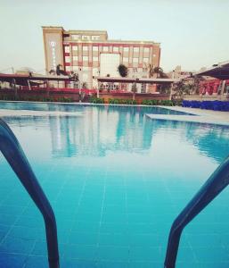 a large pool of blue water in front of a building at Rehana Plaza Hotel in Cairo