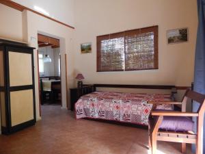 1 dormitorio con cama, mesa y ventana en Las Terrazas Resort & Apart-Cabañas en La Falda