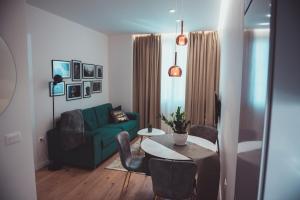 een woonkamer met een groene bank en een tafel bij TAM Serviced Apartments City Center No2 in Tirana