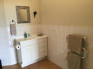 a bathroom with a sink and a mirror at Heads Up in Mangawhai