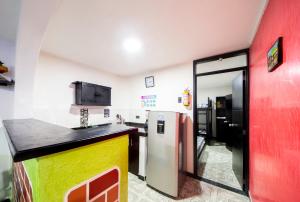 uma cozinha com um frigorífico e uma parede vermelha em Casa Quindio em Armênia