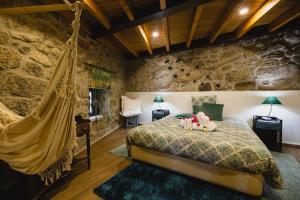 um quarto com uma cama de rede numa parede de pedra em O Cantinho da Ana em Sortelha