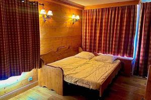 ein kleines Bett in einem Zimmer mit Fenster in der Unterkunft Appartement 5 pers. idéalement situé à Tignes le Lac in Tignes