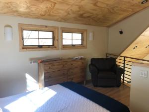 1 dormitorio con 1 cama y 1 silla en River Rock Retreat, en Idyllwild